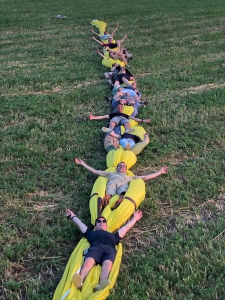 Photo ludique d’un groupe d’entreprise après le pliage de la montgolfière lors d’un team building organisé par Montgolfière Ardenne